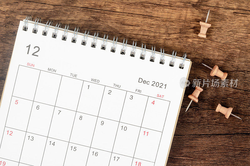 Top view Calendar desk 2021年12月，木制桌子背景上的图钉规划和截止日期的概念。